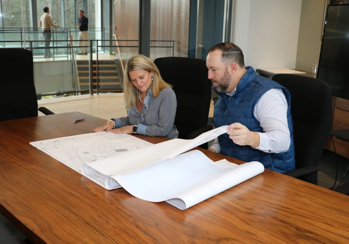 Building plans, scheatics and permit paperwork laid out across a drafting table